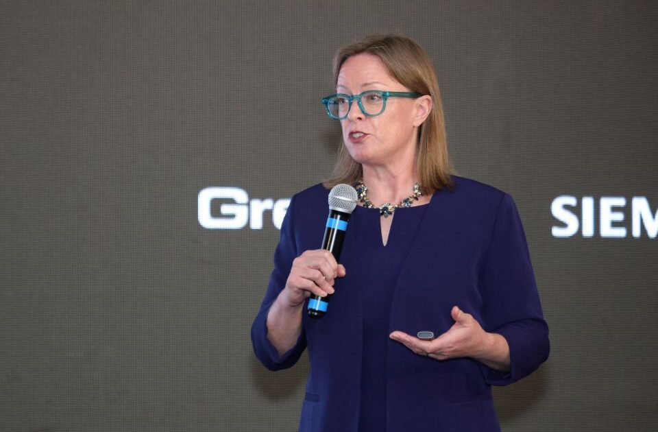 adrienne meyer in a purple suit with a gray background
