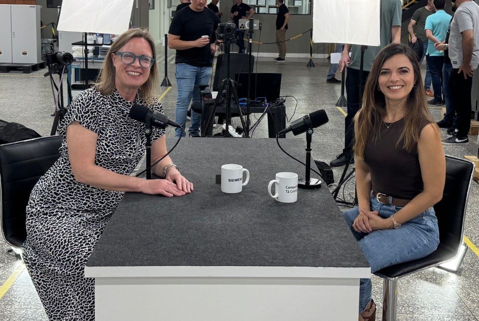 two women sitting at table with microphones